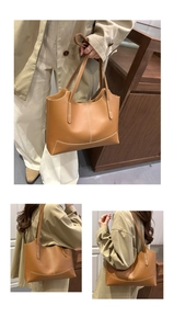 Détail d'un sac cabas marron avec des coutures contrastées blanches et de longues anses