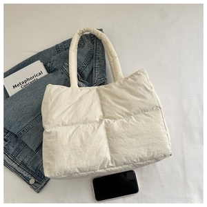 Close-up of a soft quilted puffy tote bag in cream white with a lightweight nylon texture