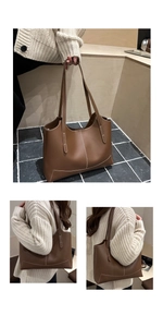 Détail du sac cabas marron montrant les coutures blanches et la texture du cuir