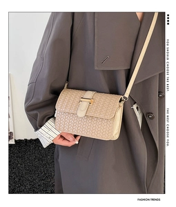 Dettaglio della borsa a tracolla intrecciata beige con chiusura in metallo dorato e trama