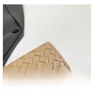 Dettaglio della trama intrecciata sulla borsa a tracolla minimalista in pelle beige
