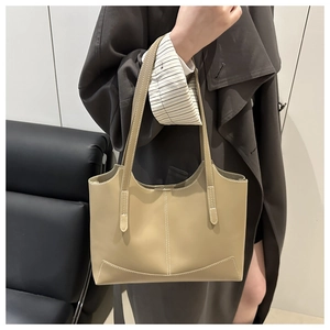 Détail d'un sac cabas kaki montrant la texture du cuir mat et les coutures verticales