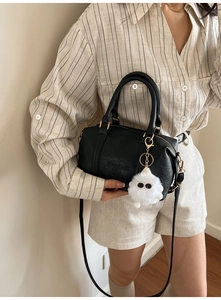 Detail of black cylindrical embossed leather handbag with Fashion Air Paris engraving