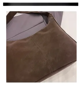 Detailaufnahme der dunkelbraunen matten Ledertasche mit vertikaler Naht und Retro-Struktur