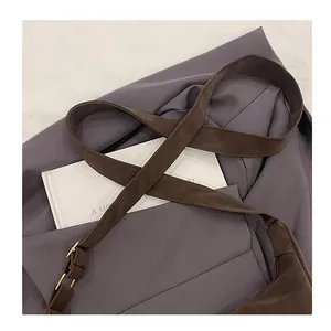 Detail eines verstellbaren Schultergurts an einer dunkelbraunen matten Lederhandtasche
