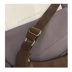 Detailansicht der matt dunkelbraunen Tasche mit goldenen Schnallen und Reißverschluss
