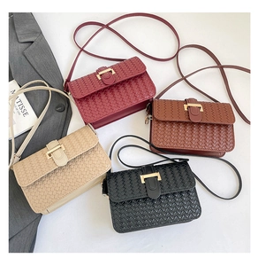 Flat lay of woven leather crossbody bags in four colors with gold metal buckles