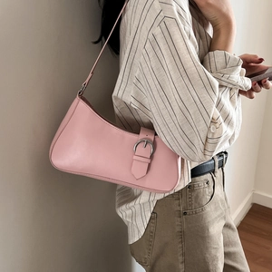 Rosa Achseltasche aus Kunstleder mit Silberschnalle, getragen von einem Modell im Studio