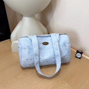 Blue fabric Boston bag with silver stars pattern and handmade metal plate on wood