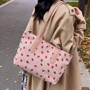 Detail of pink corduroy tote bag with strawberry embroidery and reinforced handles