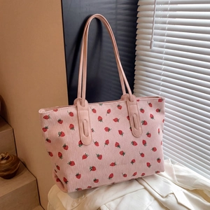 Detail of pink corduroy tote bag with strawberry embroidery and soft stripe texture