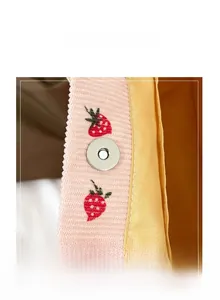 Close-up of strawberry embroidery on pink corduroy tote with magnetic metal buckle