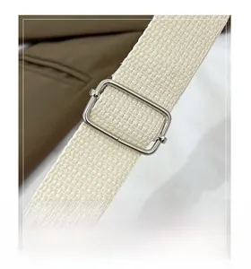 Detail of off-white woven strap with premium silver adjustable buckle on tote bag