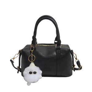 Black textured leather Boston bag with plush monster charm and Fashion Air Paris embossing