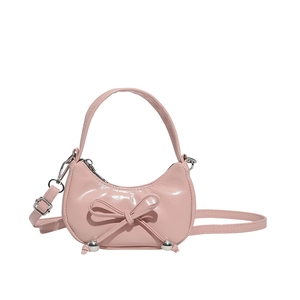 Pink patent leather dumpling bag with bow detail and adjustable strap for women