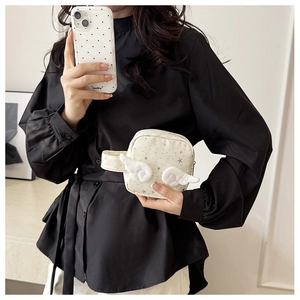 Dettaglio della trousse trucco con stelle e ali decorative in peluche su tessuto bianco crema