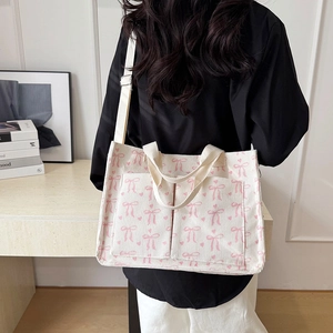 White corduroy tote bag with pink bow prints and wide canvas shoulder straps