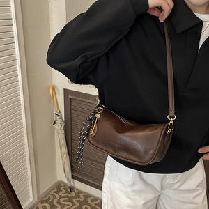 Retro brown crescent crossbody bag with golden tennis racket pendant and woven tassels