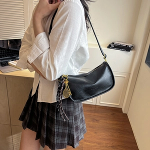 Retro black faux leather shoulder bag with gold tennis racket charm and ribbon detail