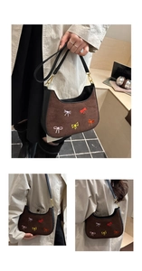 Détail d'un sac demi-lune en daim marron avec broderies nœuds colorées et ferrures dorées