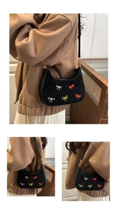 Détails du sac demi-lune noir en daim avec broderies de nœuds colorés et boucle dorée