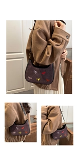 Détail du sac croissant en daim avec broderies nœuds colorés et finitions en cuir noir