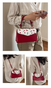 Détails de l'imprimé cerise et de l'anse nouée élégante sur le sac à main rouge cerise