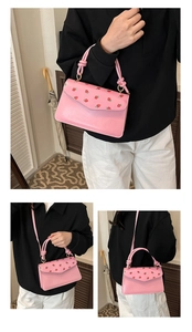Vue détaillée du sac rose avec imprimé fraises et poignée nouée élégante