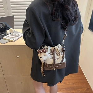 Large capacity drawstring bucket bag with printed cat motif and plush bear pendant detail