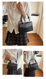 Détails du sac bandoulière noir imprimé cerise avec nœud rose et poignée torsadée