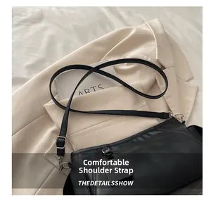 Detail of adjustable black leather strap and silver buckle on chic shoulder bag