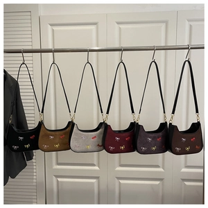 Détail des broderies de nœuds colorés sur sacs hobo en daim disponibles en six coloris