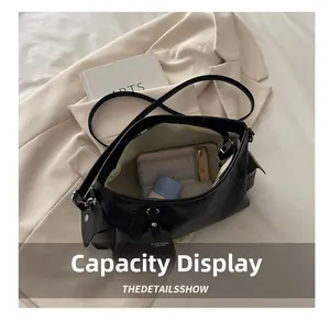 Top view of spacious black leather tote interior showing phone, wallet and cosmetics