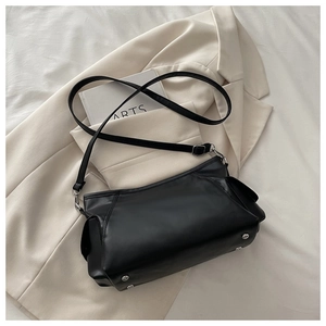 Detailed view of black faux leather bag with silver studs and adjustable strap