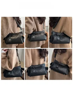 Model wearing a black leather underarm bag with multi-pocket design and adjustable strap