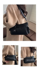 Detail view of the black matte leather tote bag with a decorative fashion tag and strap