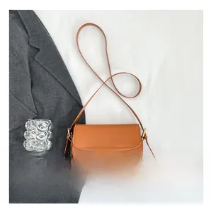 Détails d'un sac à rabat marron minimaliste avec boucles métalliques dorées élégantes
