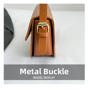 Gros plan détaillé du sac à bandoulière en cuir marron avec boucle métallique dorée