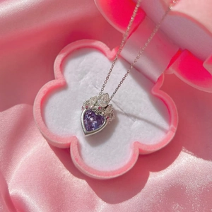 Élégant collier couronne avec pierre violette en forme de cœur dans son écrin floral