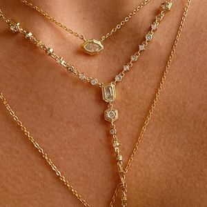 Three-layer gold necklace set with zircon pendants shown on a model's neckline