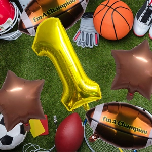 Super Bowl theme balloon set with gold number and rugby shapes on green grass background