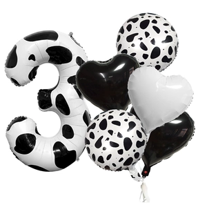 Detailed set of black and white cow print foil balloons for 3rd birthday party decor