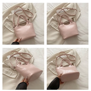 Close-up of pink fashion handbag with embossed cartoon patterns and adjustable strap