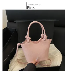 Pink embossed handbag with cartoon bunny and heart patterns on a luxury gift box background