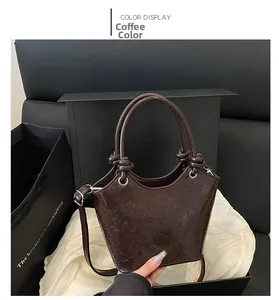Macro detail of the coffee-colored handbag featuring love and heart embossed patterns