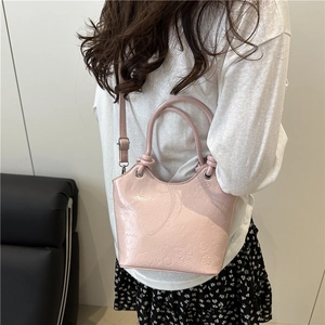 Pink trendy bucket bag with embossed patterns and adjustable shoulder strap for women