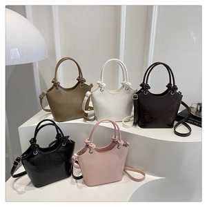 Detail of five colorful bucket bags with kitty embossing and knotted handle accents