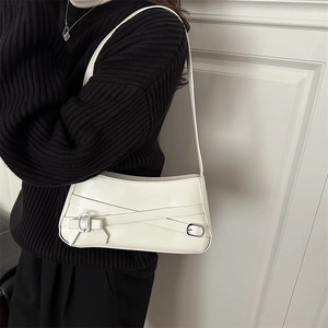 Sac à bandoulière blanc chic avec boucle en argent porté par un mannequin pour femme élégante