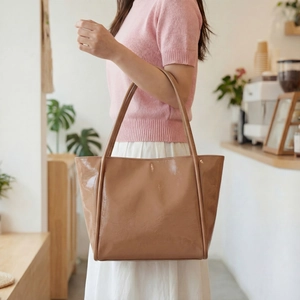 Chic caramel brown glossy leather tote bag for women featuring spacious trapezoid design
