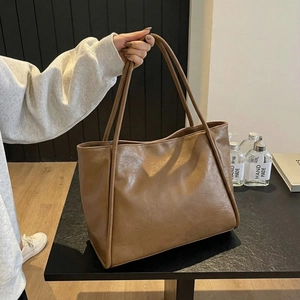Detailed view of brown PU leather tote bag with soft texture and slim shoulder straps